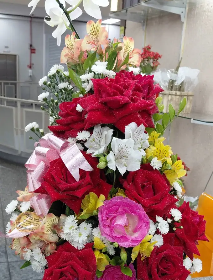 Arranjo de rosas vermelhas e cor-de-rosa com orquídea branca numa caixa de madeira