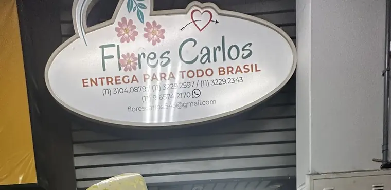 Placa da loja: Flores Carlos, entrega para todo Brasil, com os telefones